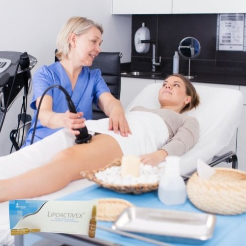 Esteticista haciendo tratamiento a mujer joven con LipoActivex tratamiento reductor