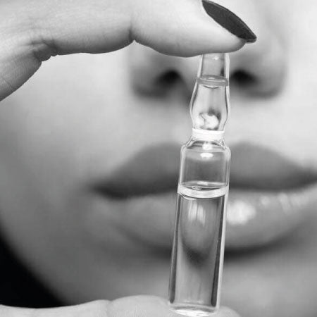 Mano de mujer con ampula de Mesoterapia Virtual.